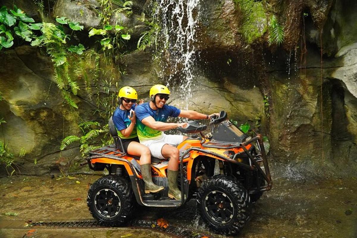Dos hombres sentados en un vehículo todo terreno frente a una cascada