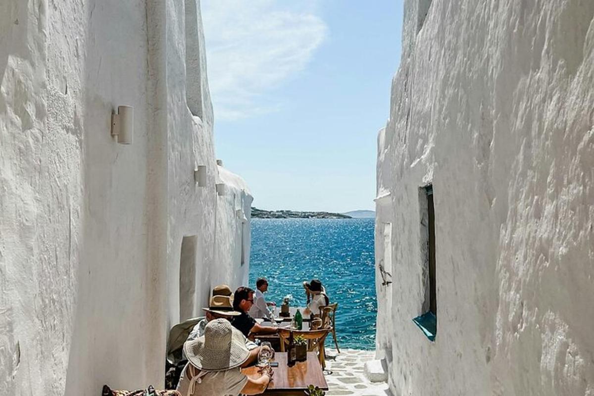 a group of people sitting at tables near the water