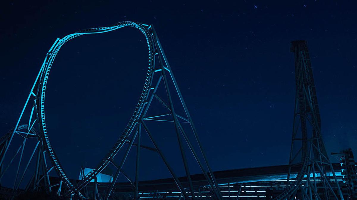 a roller coaster at night with a dark sky