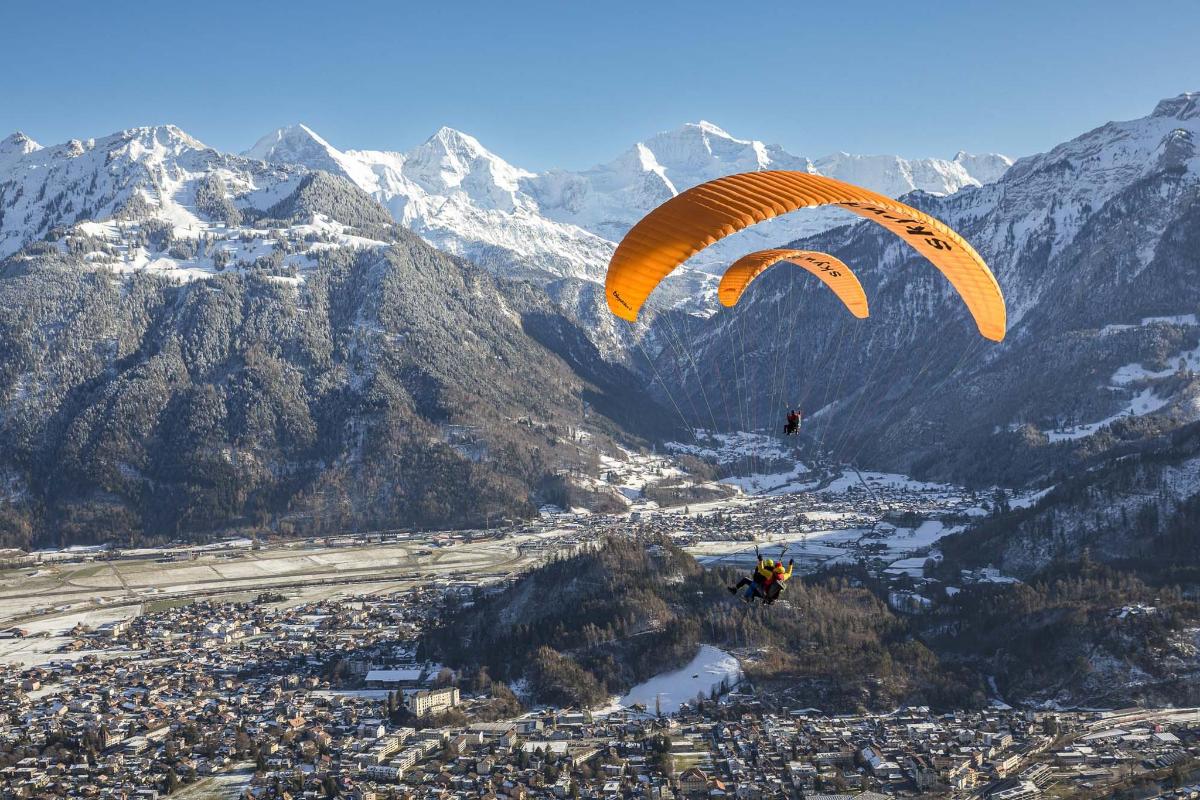 una persona que practica parasailing en el aire con un paracaídas