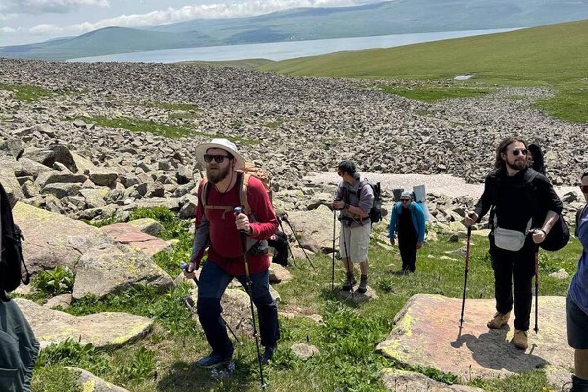 un gruppo di persone che camminano su una collina rocciosa