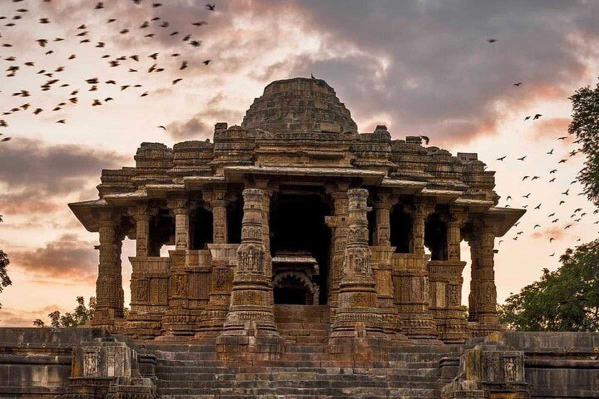 a large stone building with a flock of birds