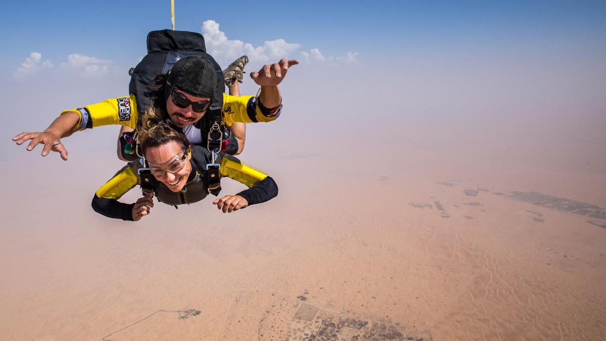 zwei Menschen fliegen durch die Luft über der Wüste