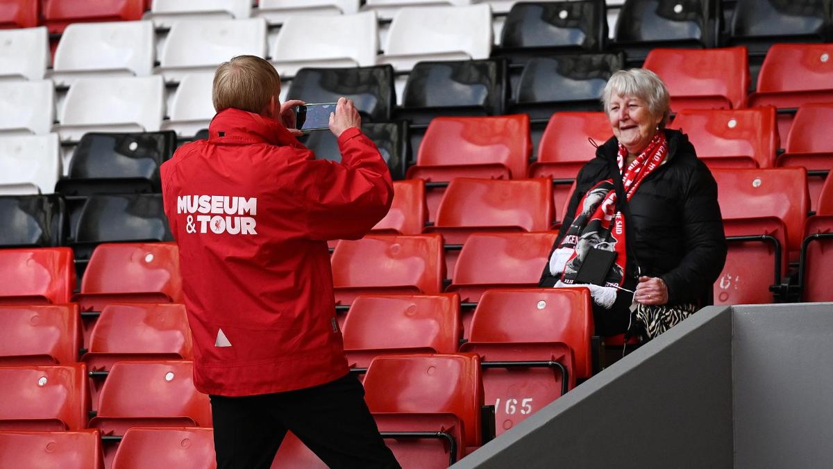 a man taking a picture of a woman in the stands