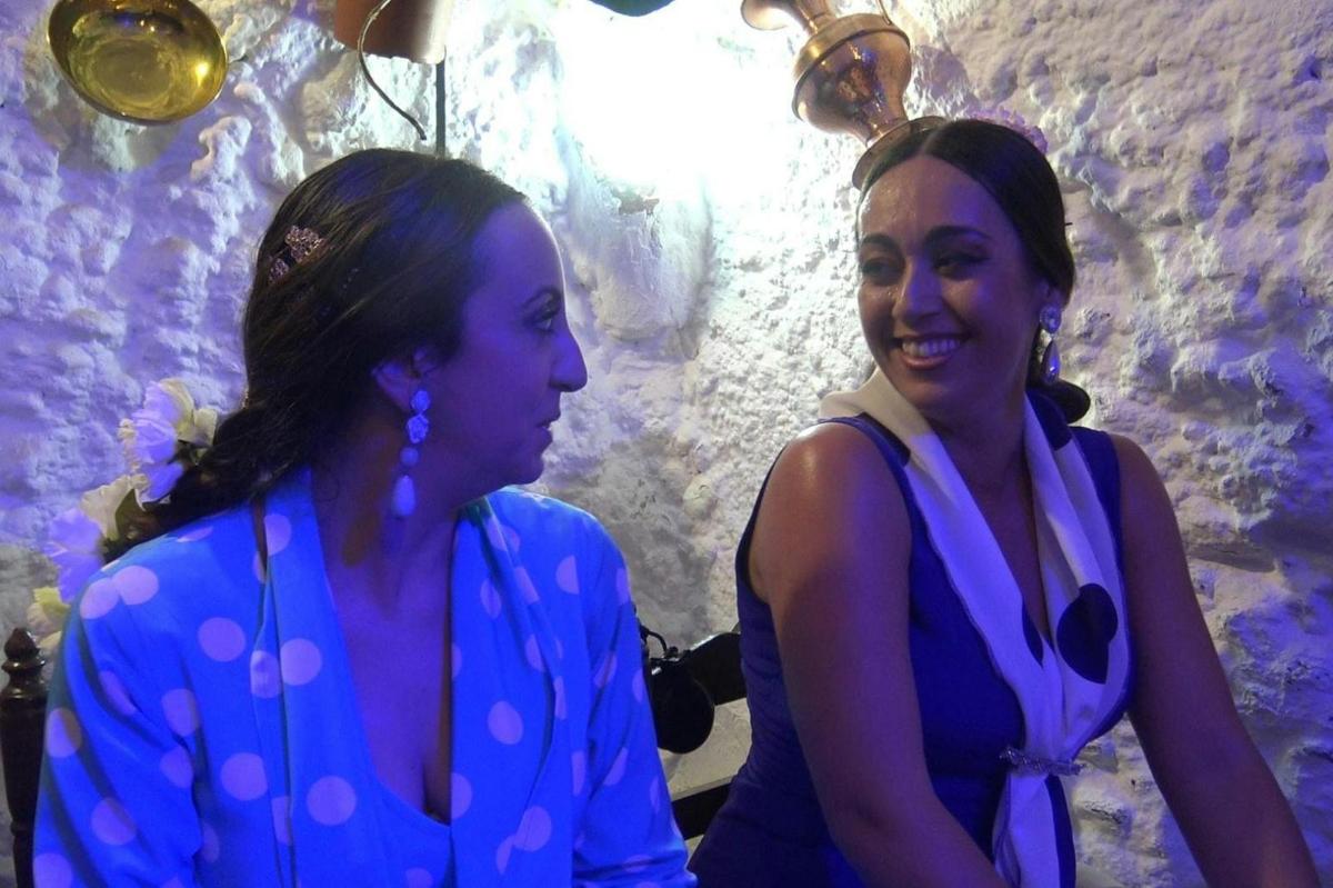 two women standing next to each other in a cave