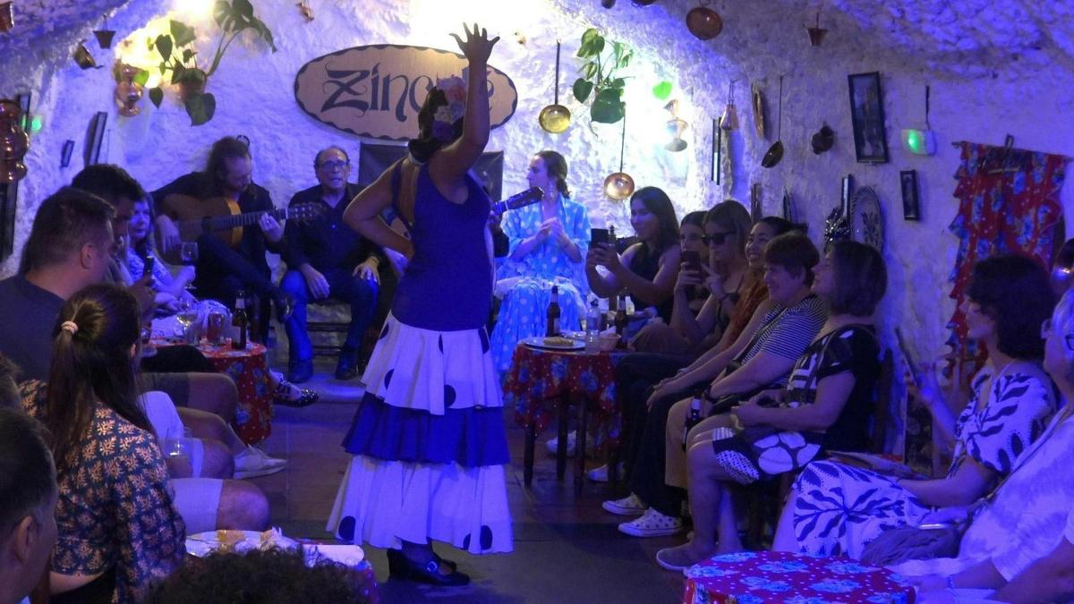 a woman standing in a room with a crowd of people