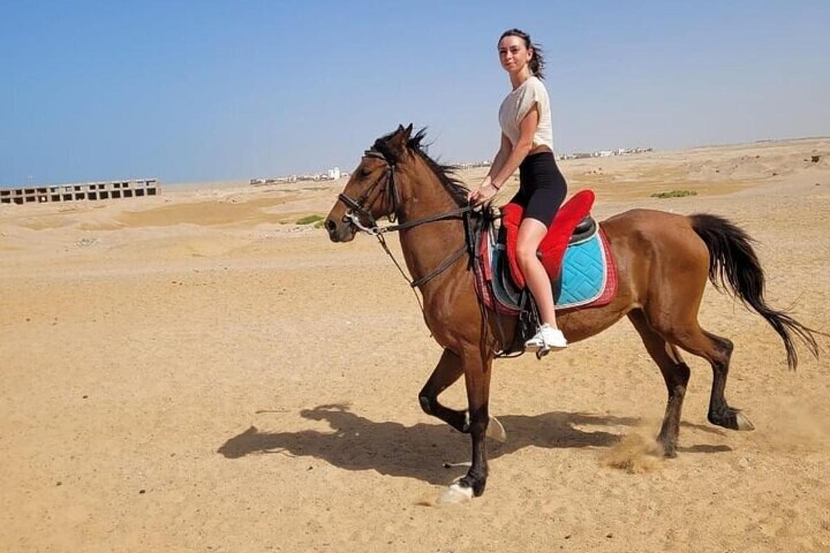 una donna a cavallo sulla spiaggia