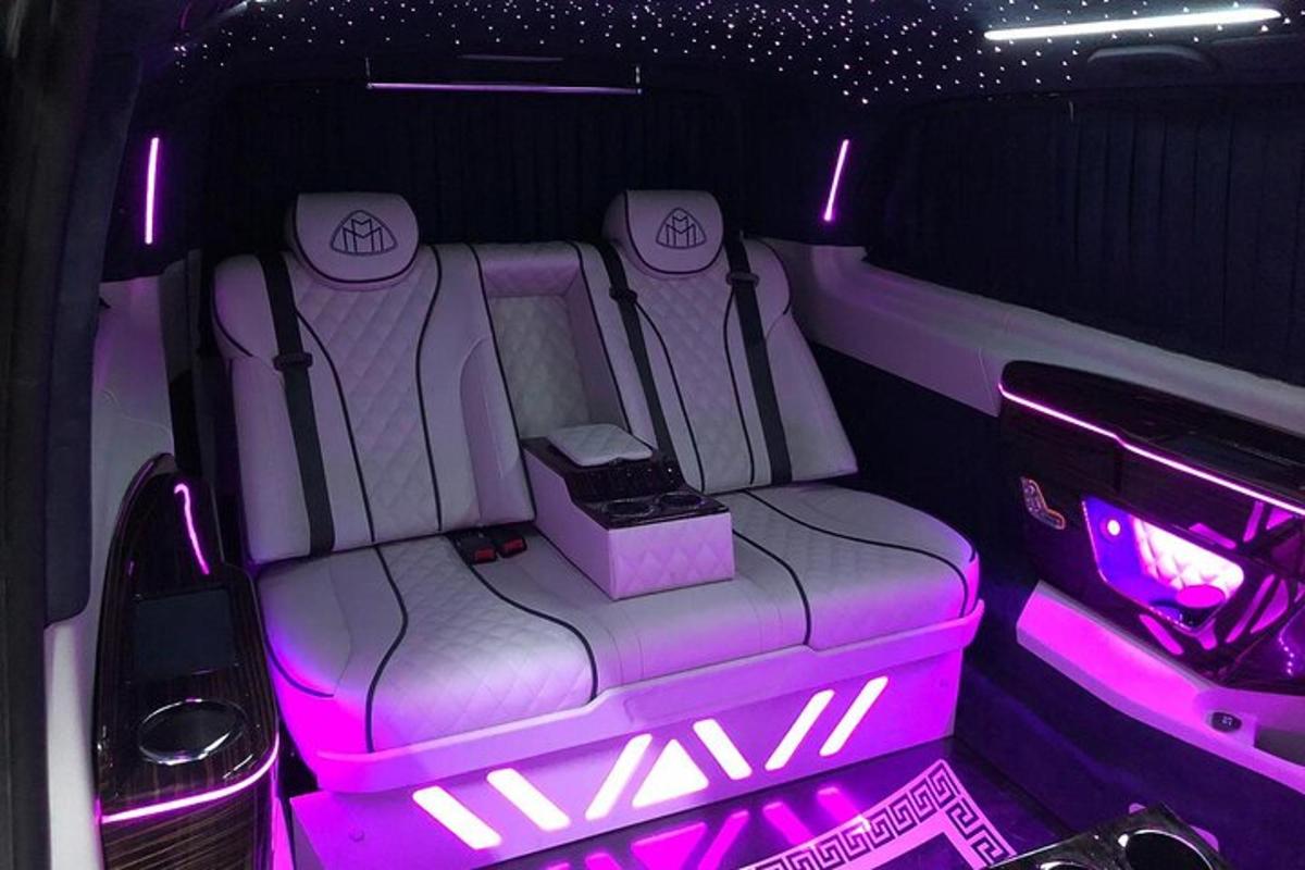 an open back seat of a limo with pink lights