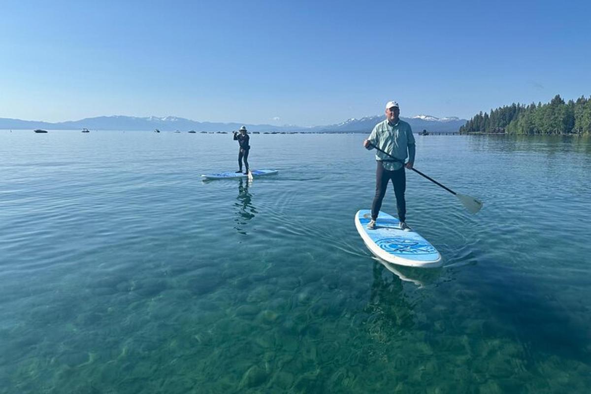 dva lidé stojí na paddleboardech ve vodě