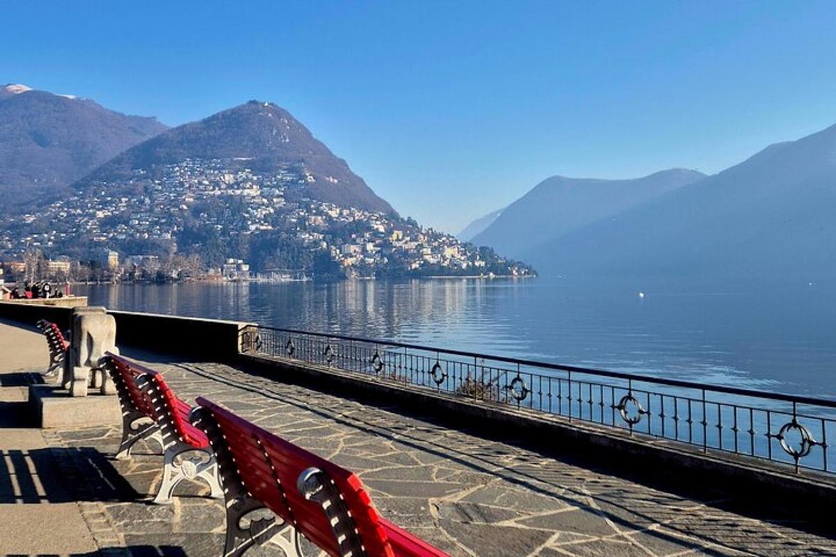 two red benches sitting next to a body of water