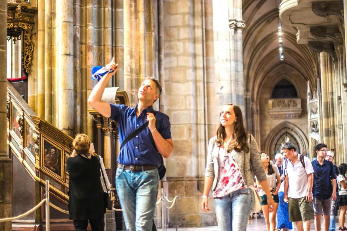 Gente caminando en una catedral con un hombre sosteniendo un micrófono