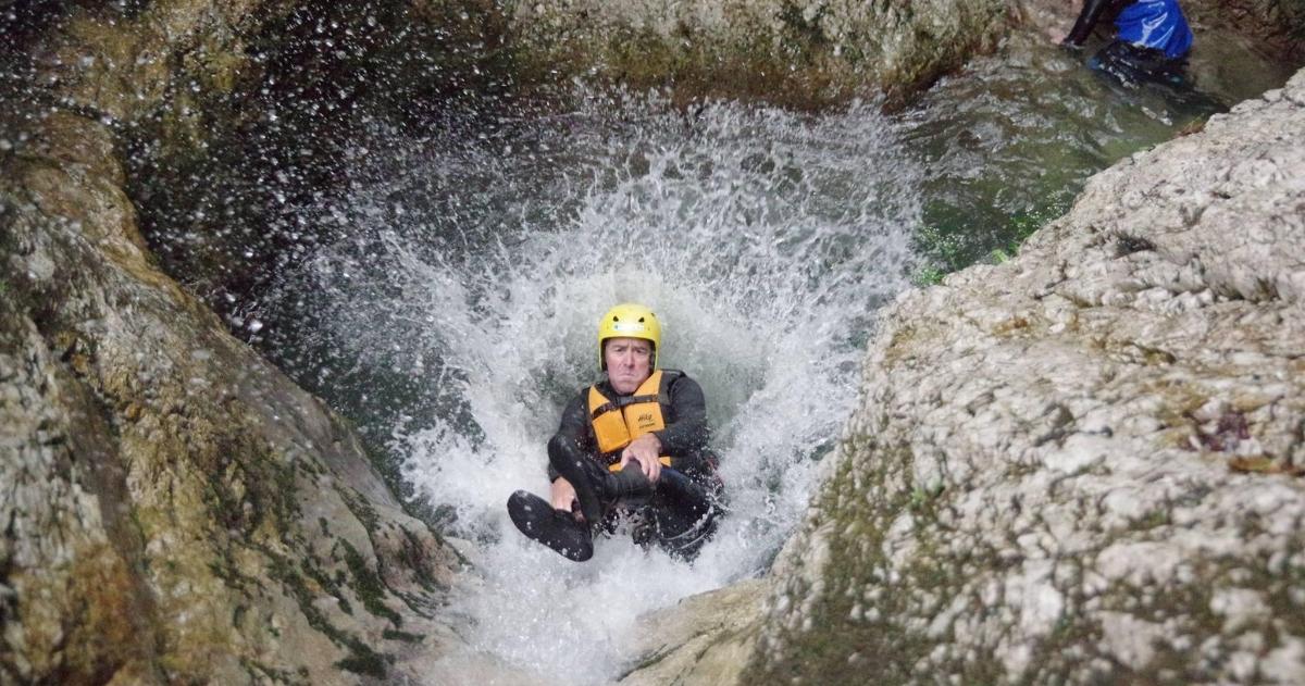 a man in a yellow helmet is in a waterfall