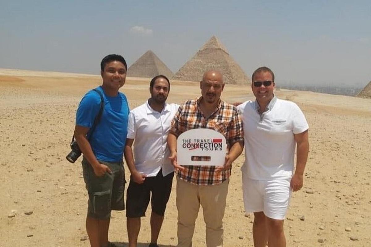 en gruppe mænd, der holder et skilt foran pyramider