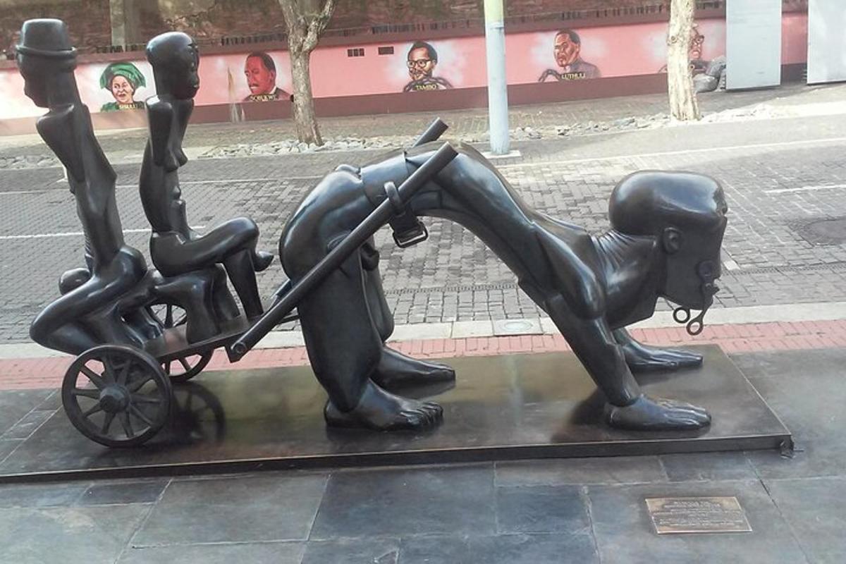 a statue of a dog pulling a child in a cart