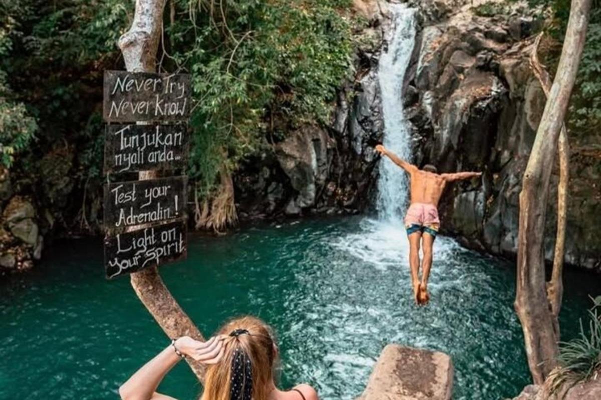due persone che saltano da una cascata in un fiume