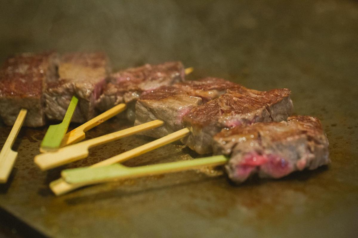 桌子上放着一堆肉和筷子