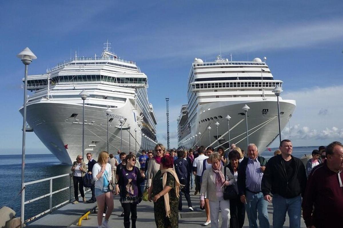 een groep mensen die op een dok lopen met twee cruiseschepen