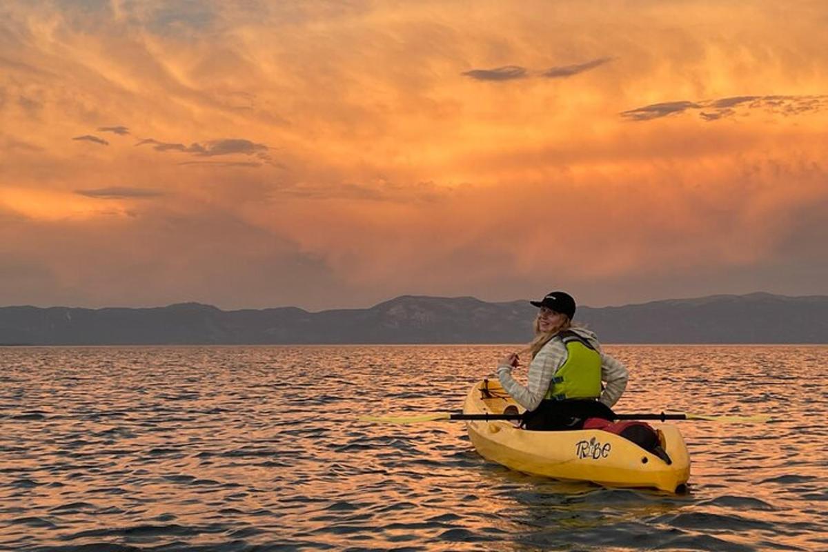 a man in a kayak in the water at sunset
