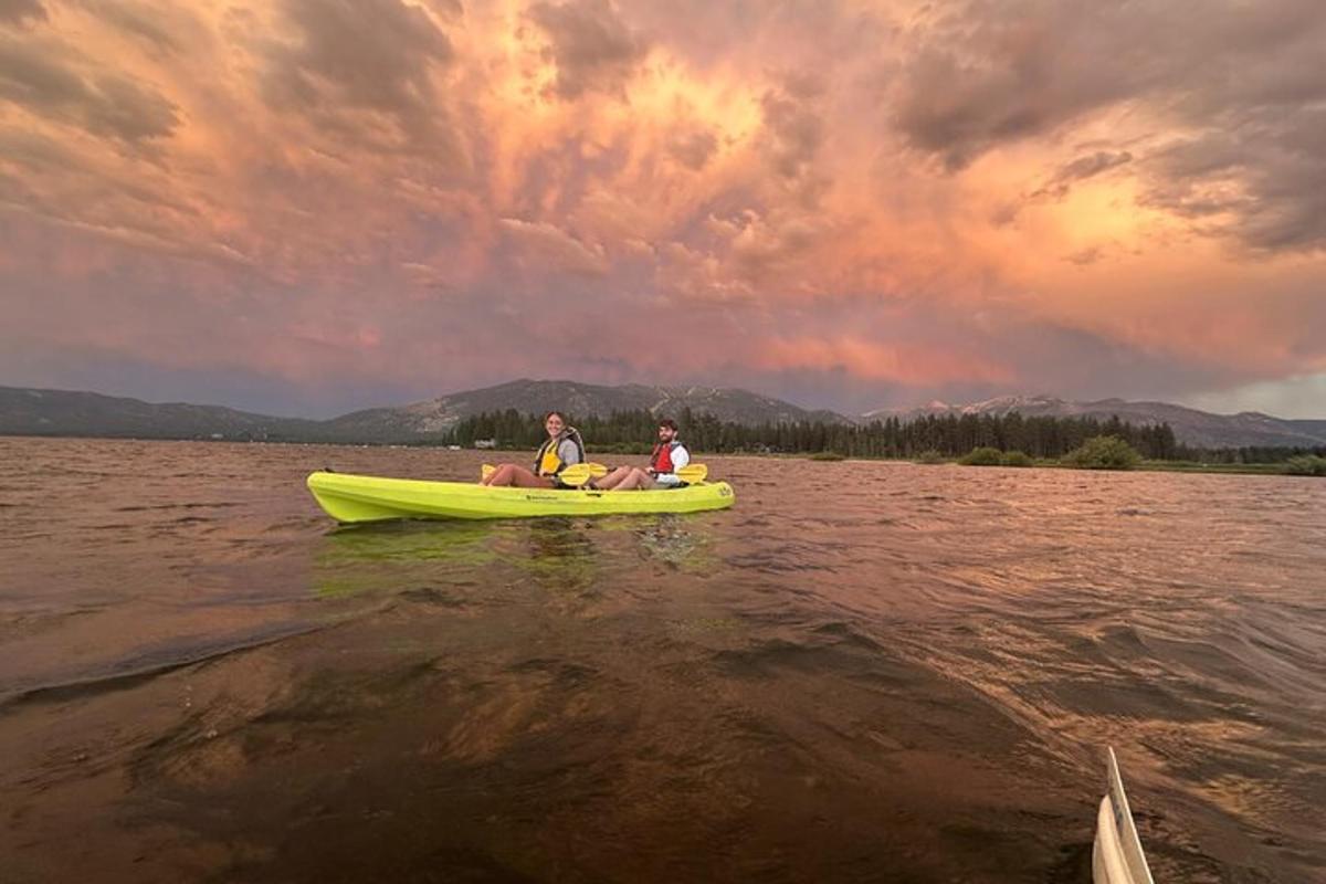 Dos personas sentadas en un kayak amarillo en el agua.