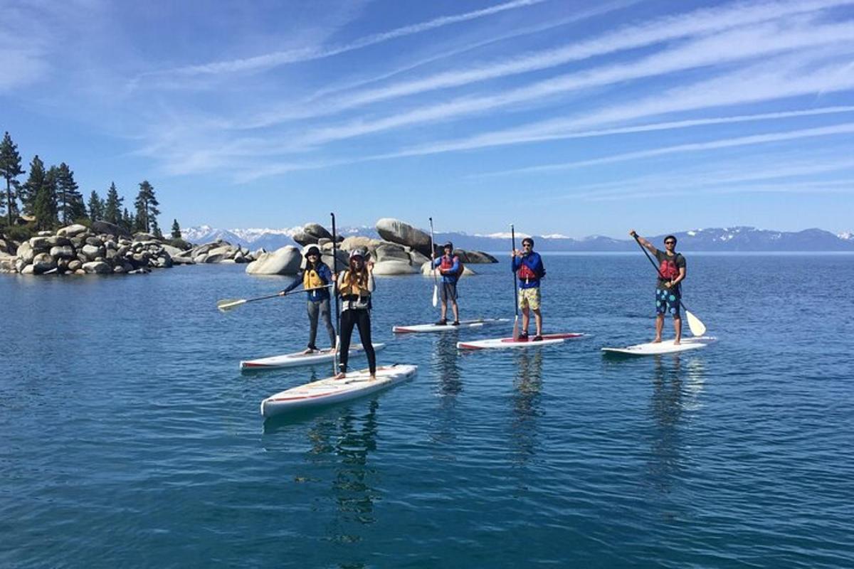 un grup de persones sobre taules de paddle surf a l'aigua