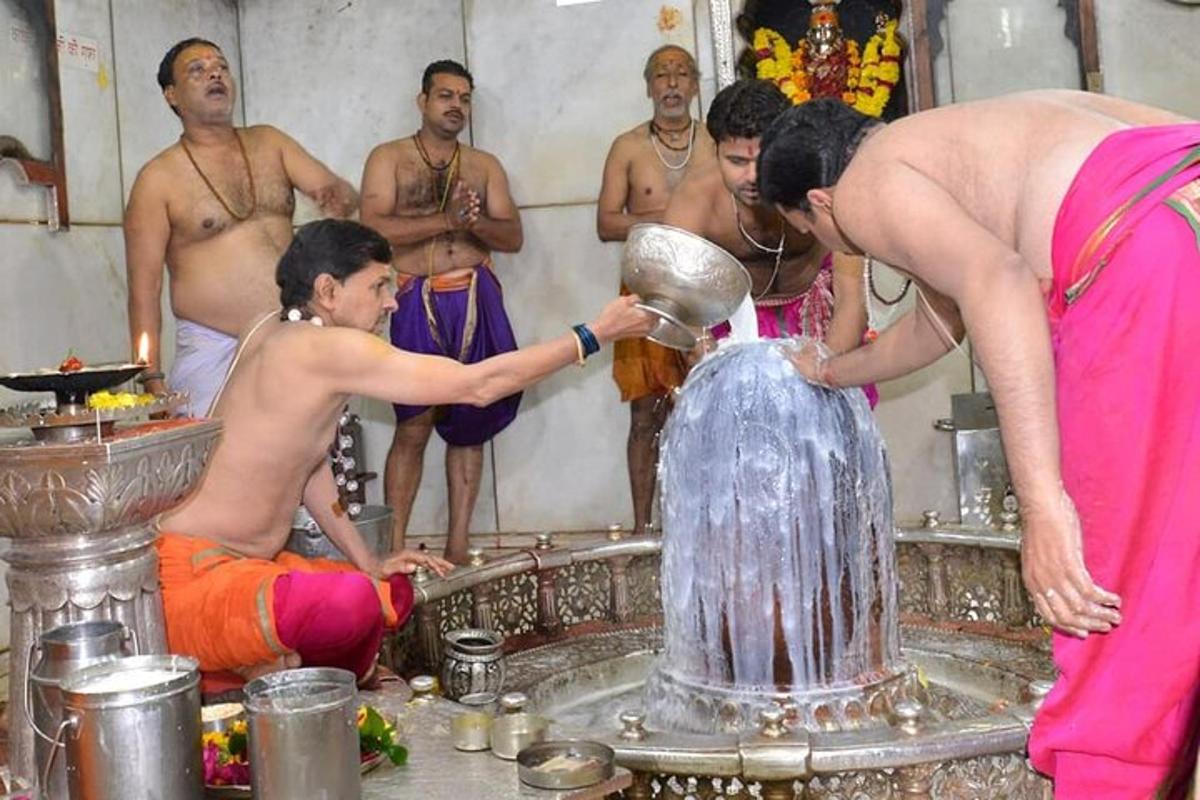 a woman pouring water into a fountain with a group of men