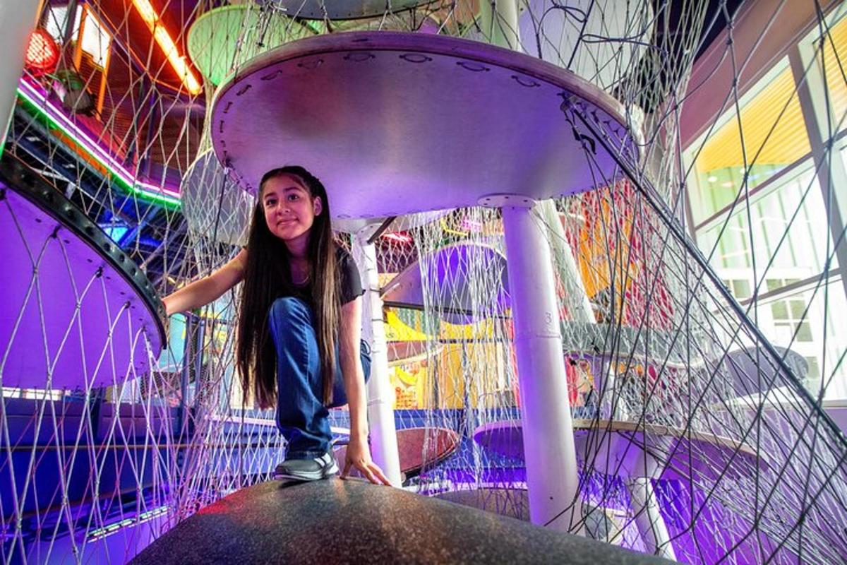 a girl is standing on a ride in an amusement park
