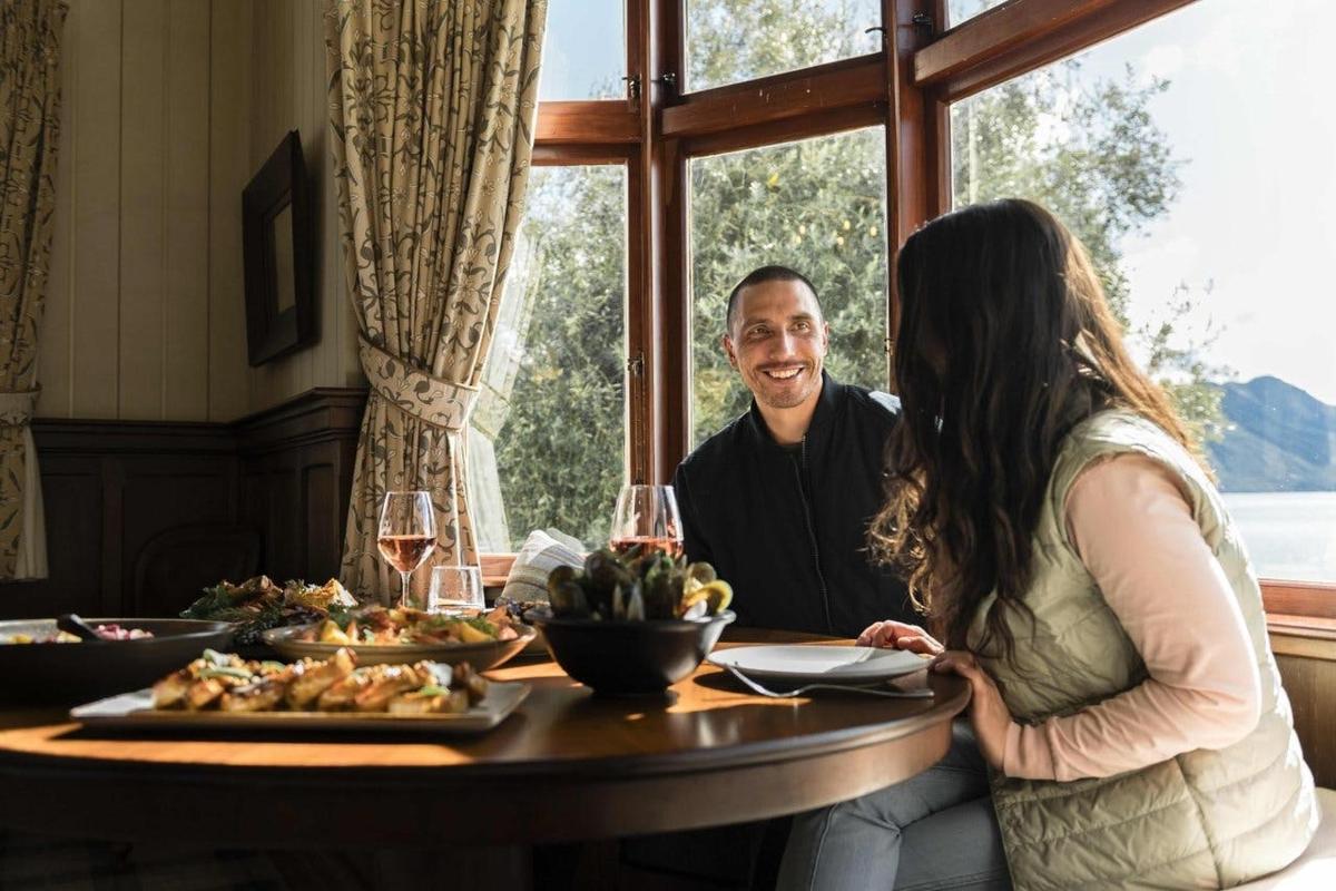 a man and a woman sitting at a table with food