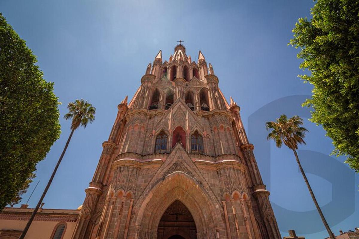 a tall tower with palm trees in front of a building