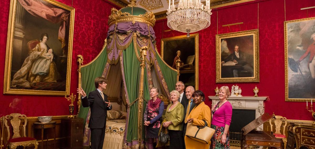a group of people standing in a room with a room with paintings
