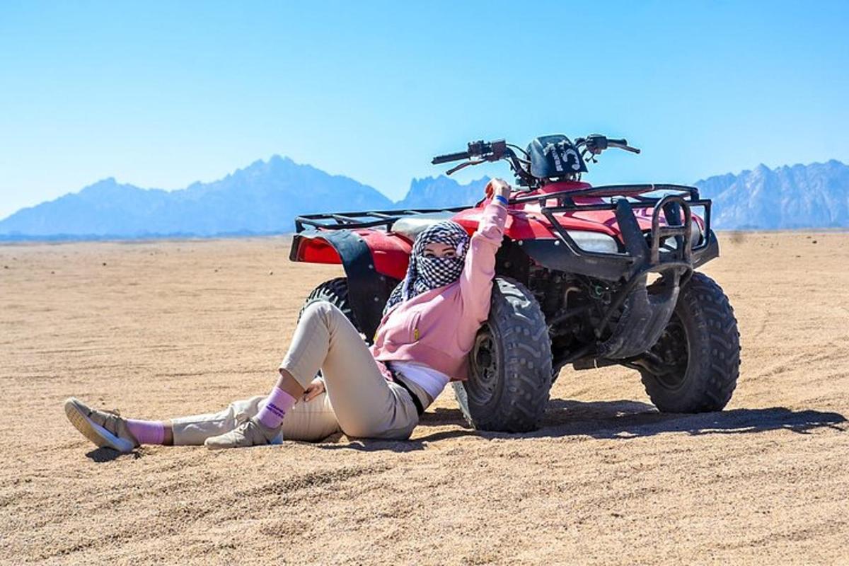een vrouw die op de grond ligt naast een crossmotor