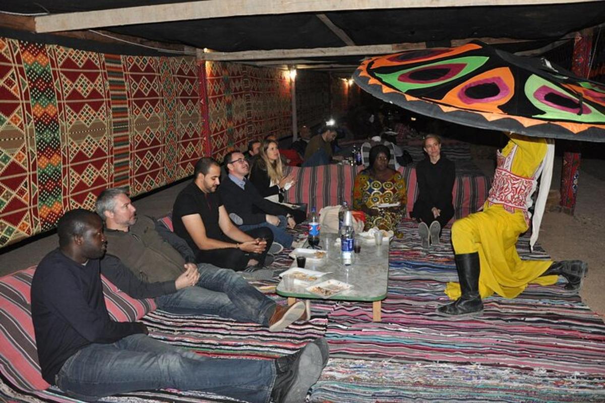 een groep mensen die rond een tafel in een kamer zitten