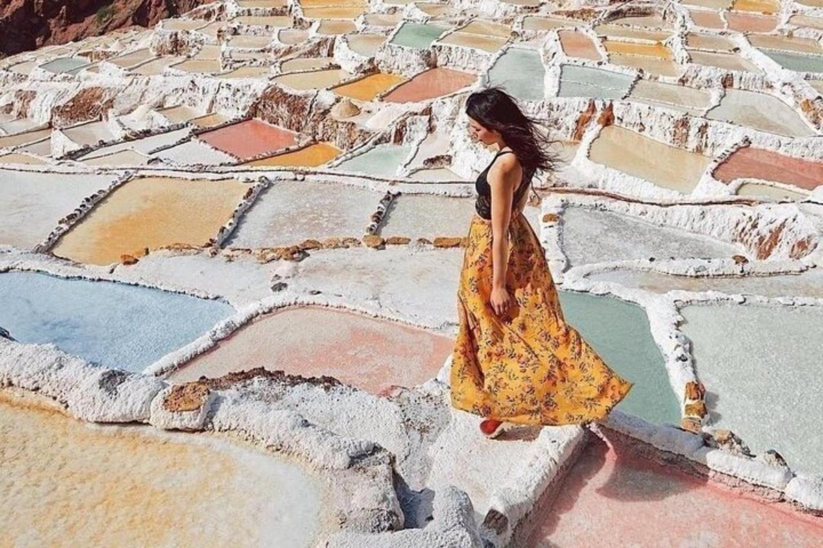 Una mujer con un vestido parada en la cima de una montaña
