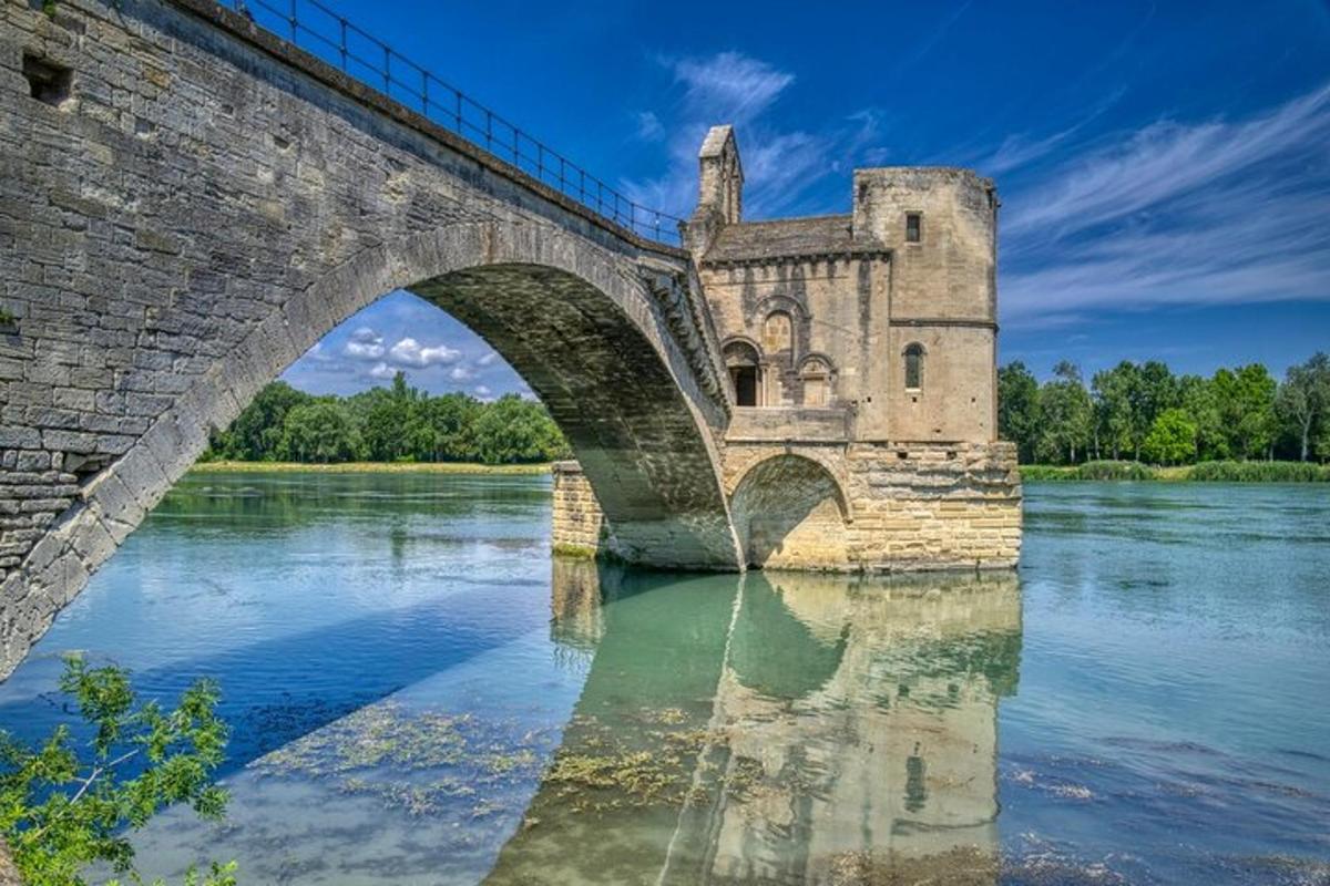 an old bridge over a river with a castle