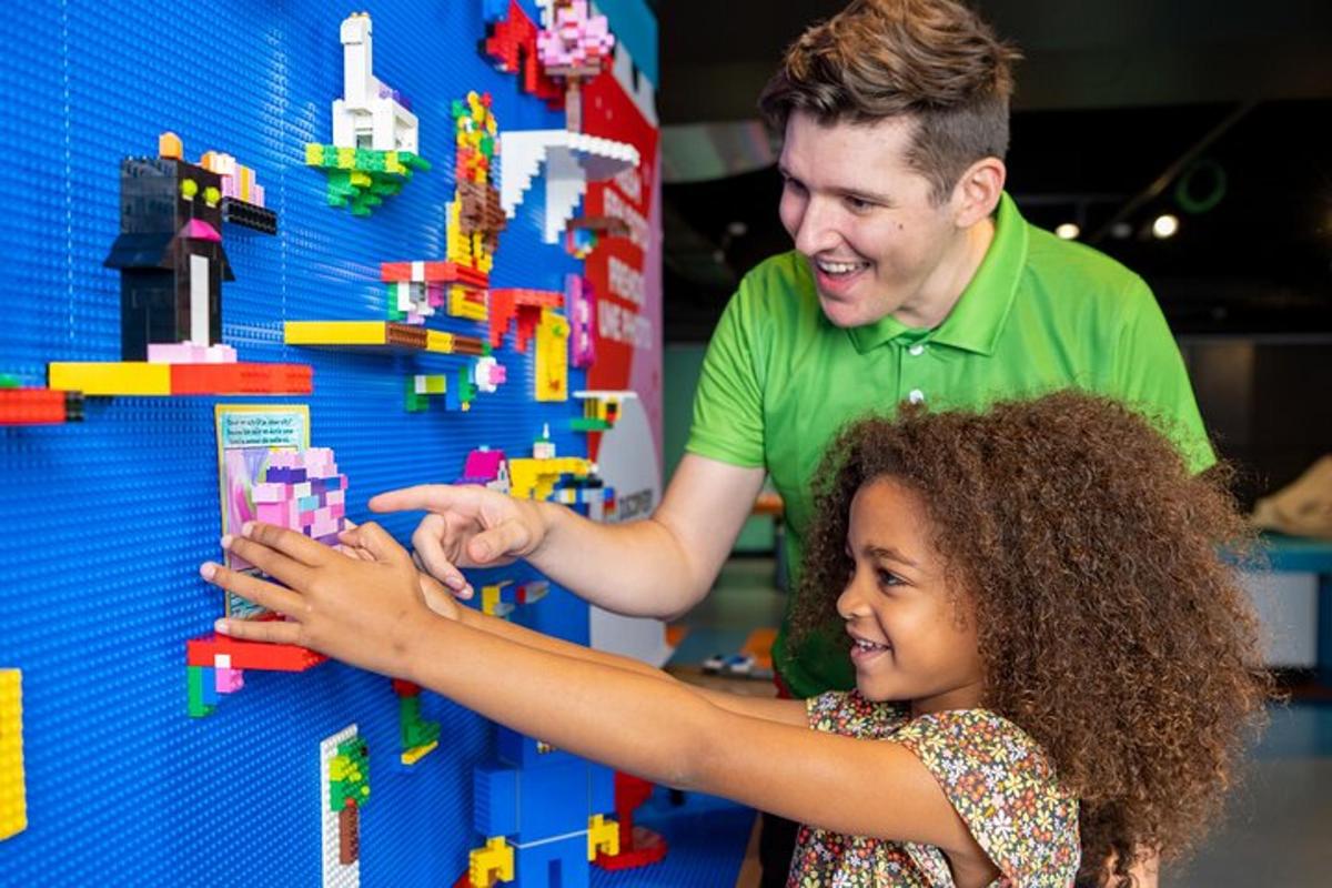 a man and a little girl playing with legos