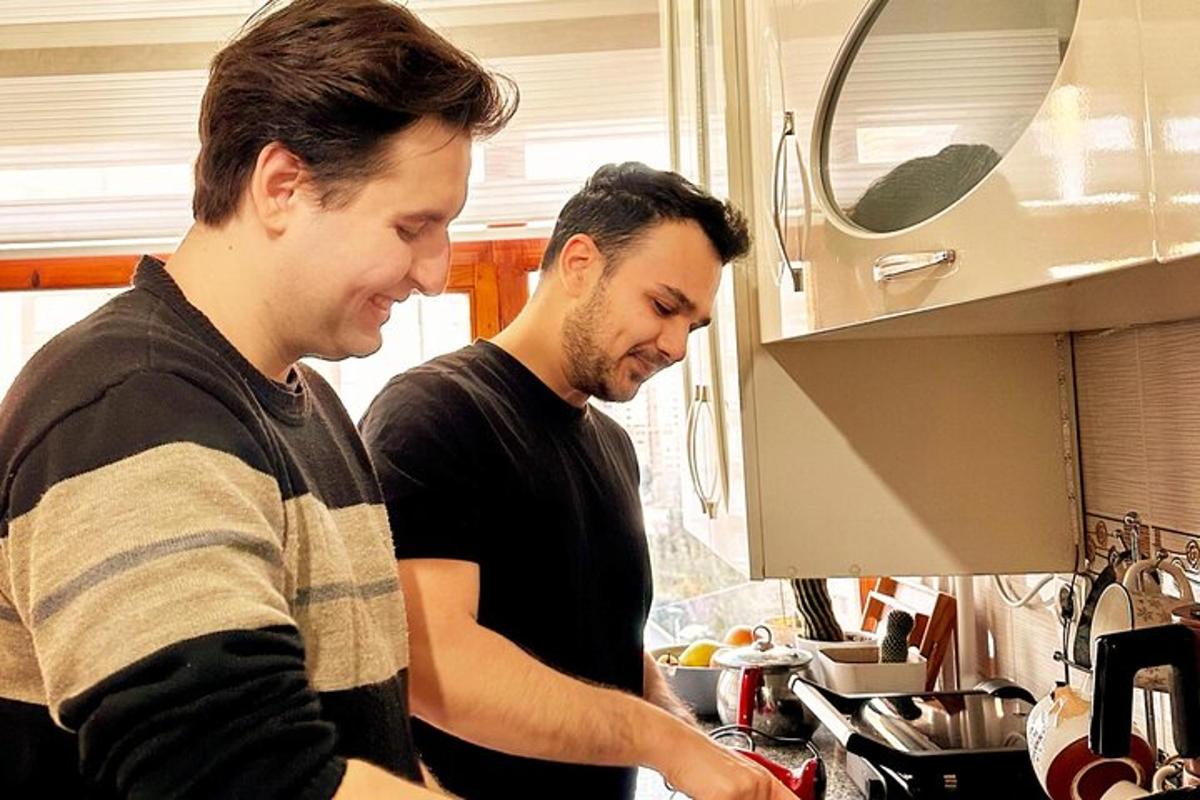 two men standing in a kitchen preparing food