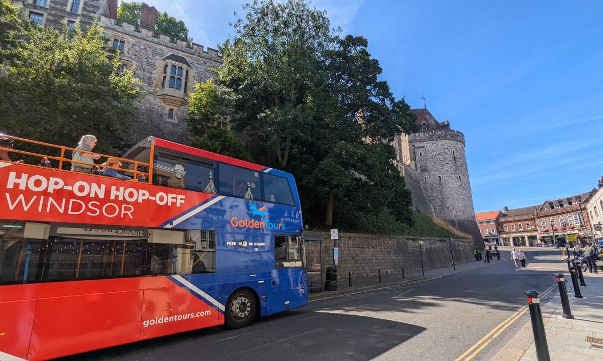 un bus à impériale rouge et bleu circulant dans une rue