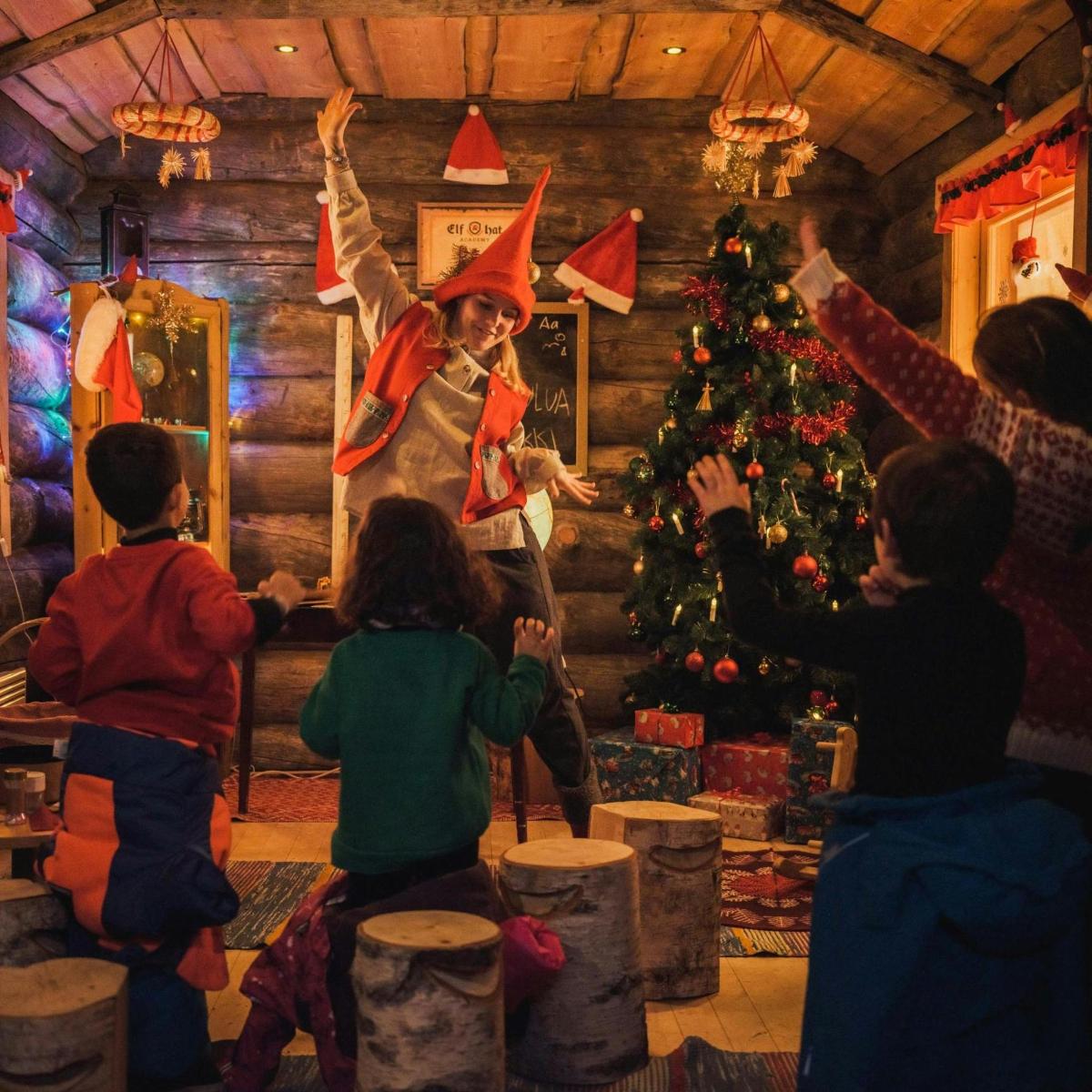 a group of children standing around a christmas tree