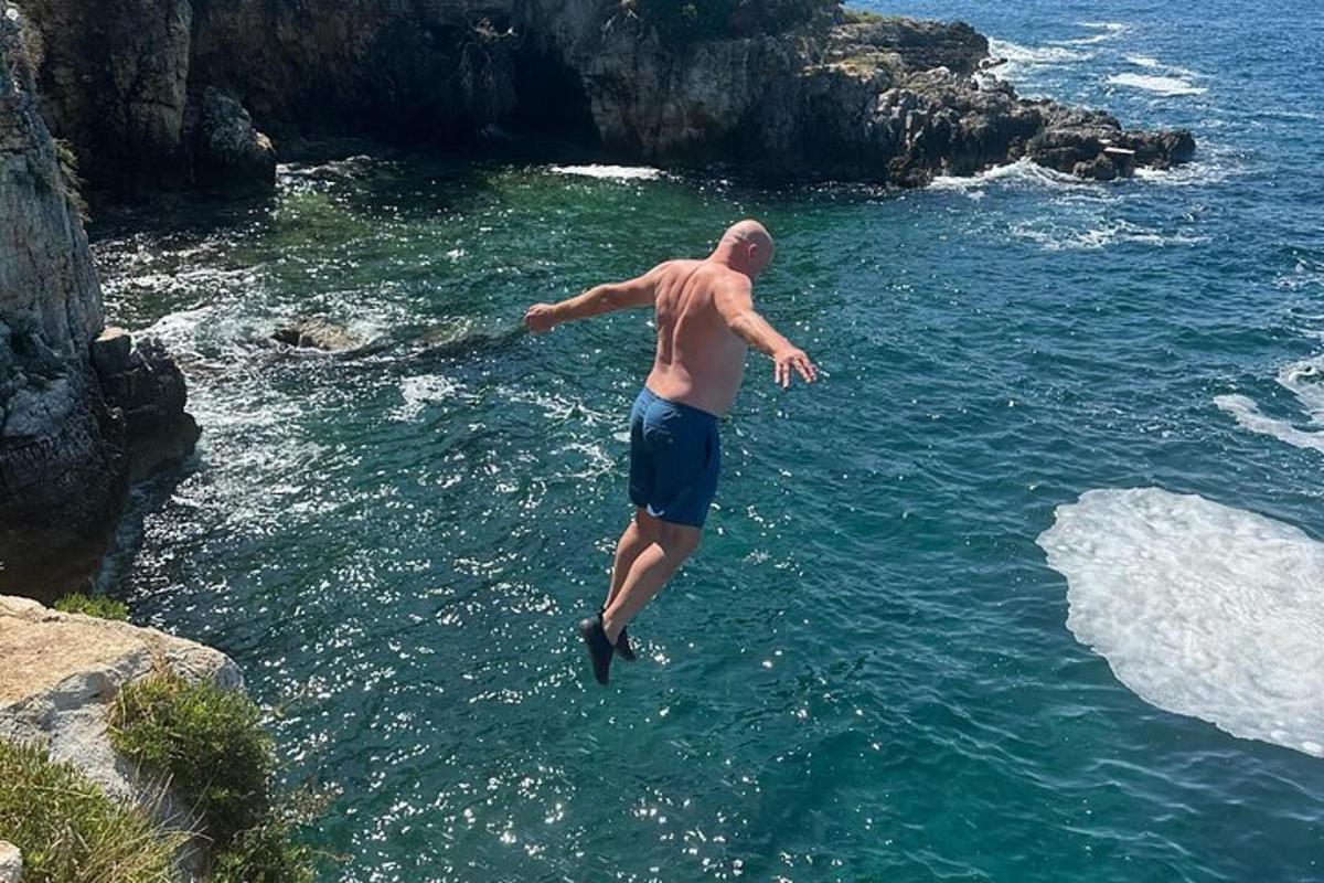 a man jumping into a body of water