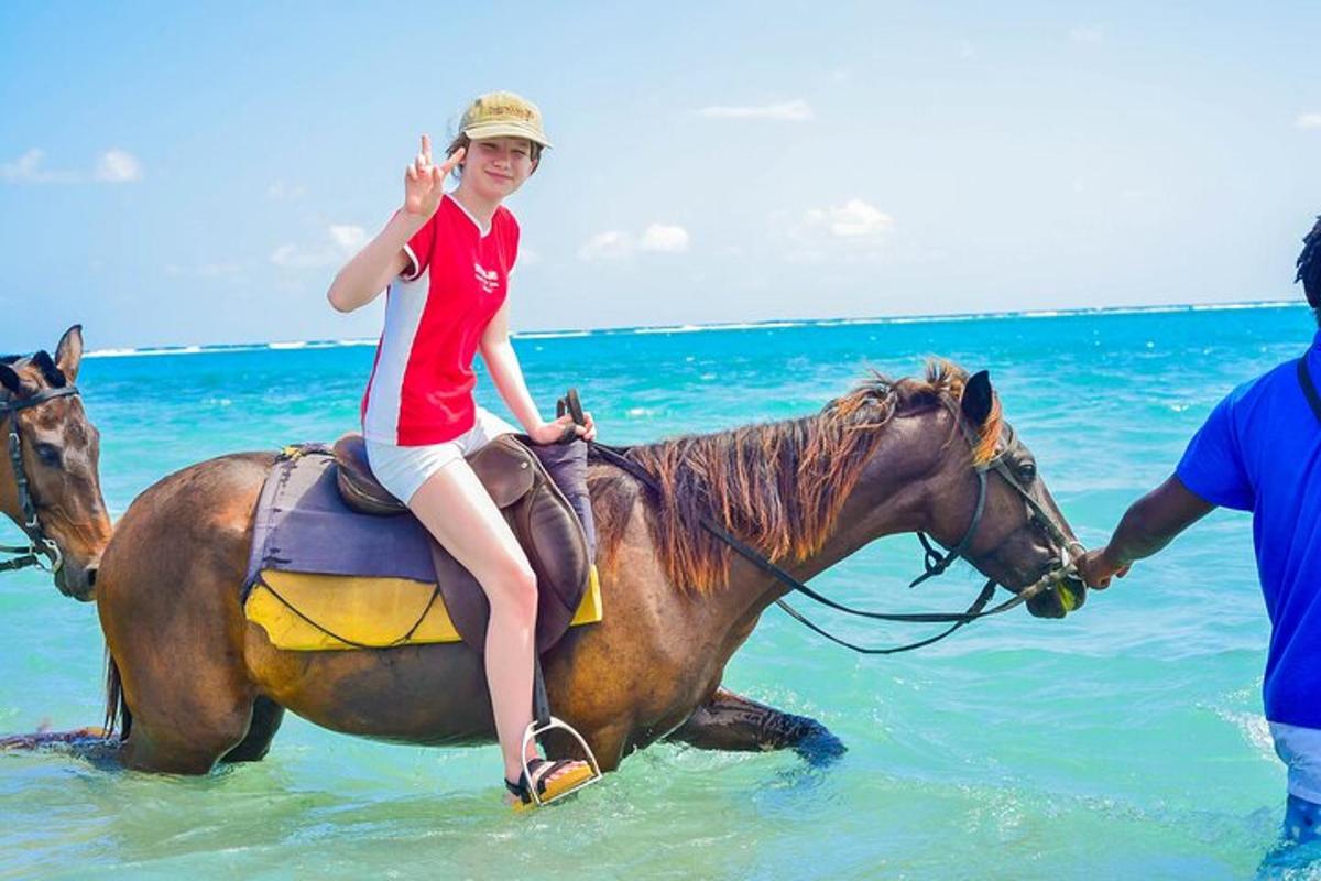 a young girl riding a horse in the ocean