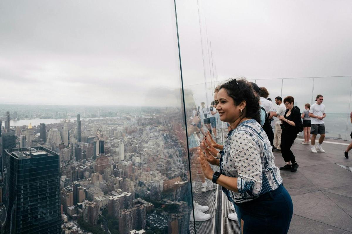 a woman standing at the top of a skyscraper