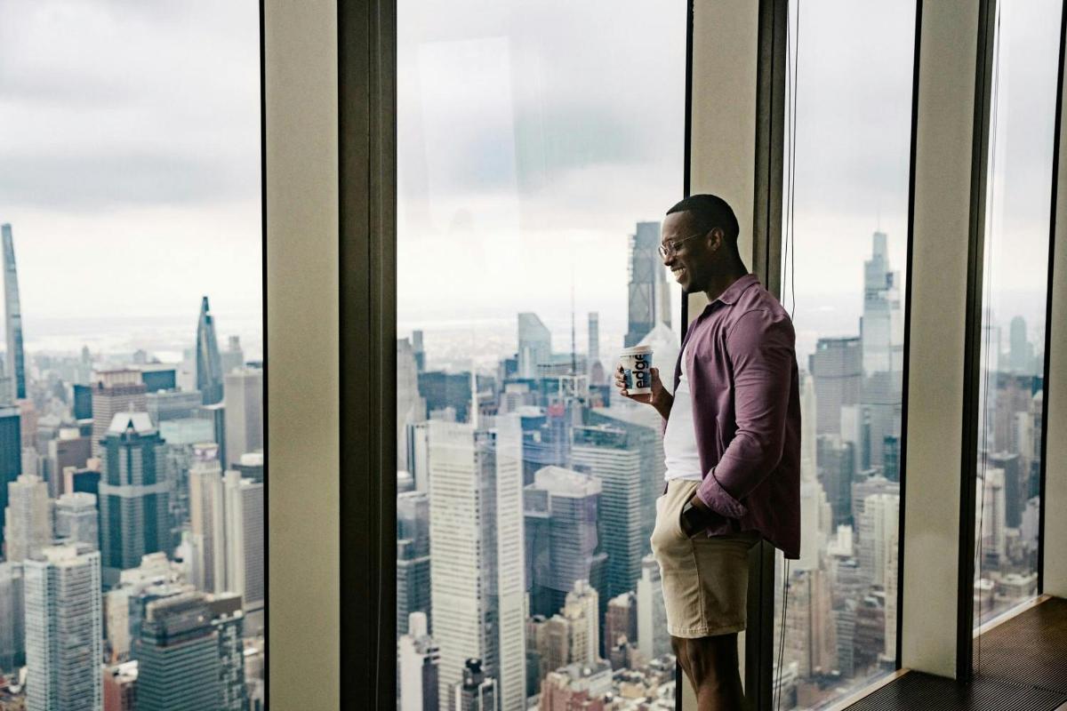 a man standing in front of a window in a skyscraper