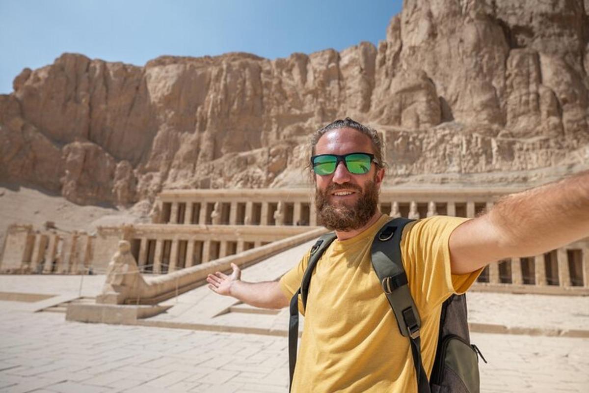 a man in sunglasses standing in front of a building