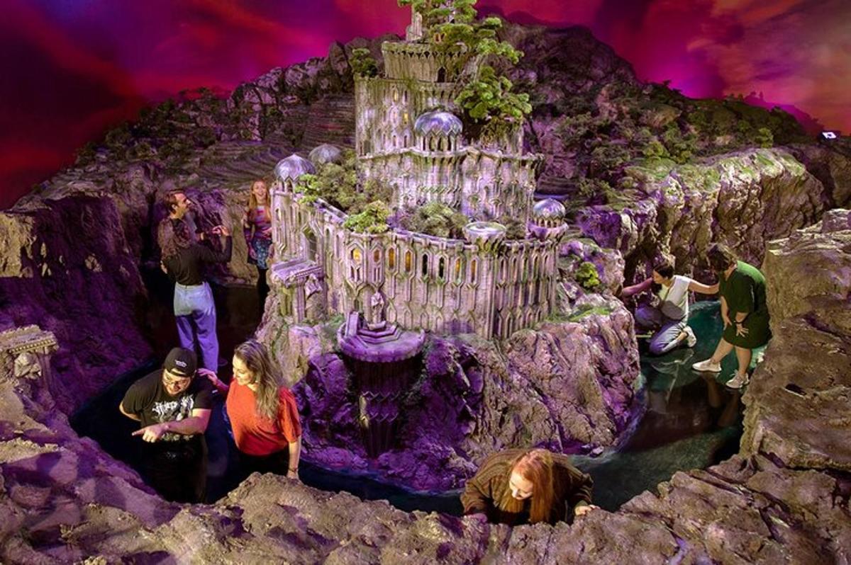 a group of people standing around a model of a castle