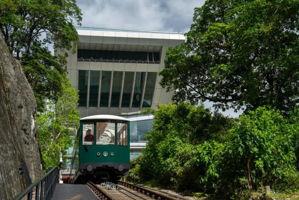 a green train on tracks in front of a building
