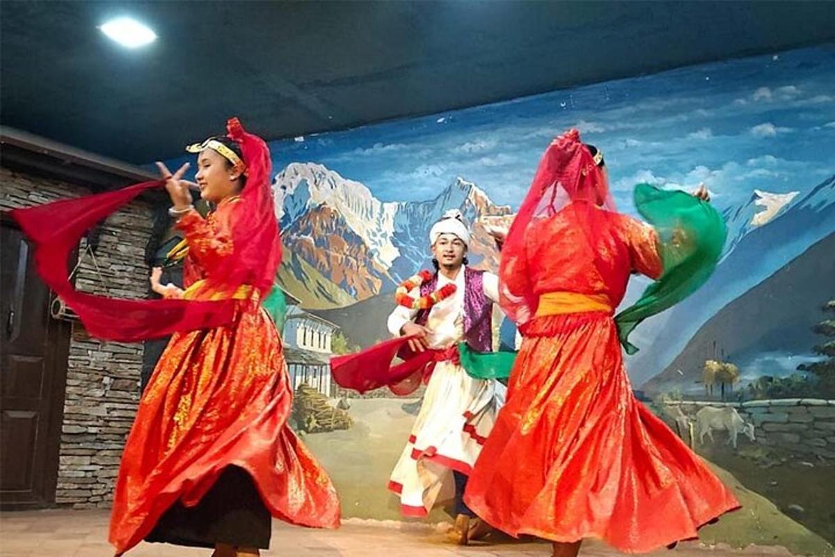 three women performing a folk dance in front of a mural