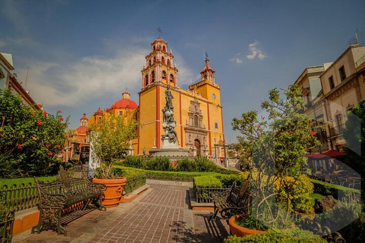 a building with a clock tower with benches in front of it