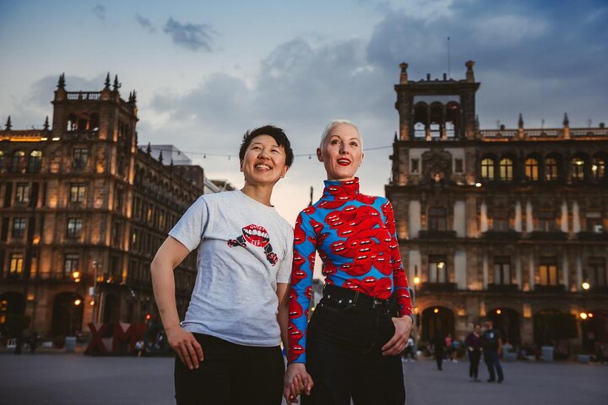 two women standing next to each other in a city