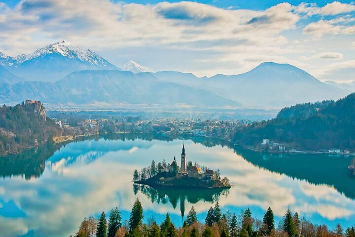 an island in the middle of a lake with mountains