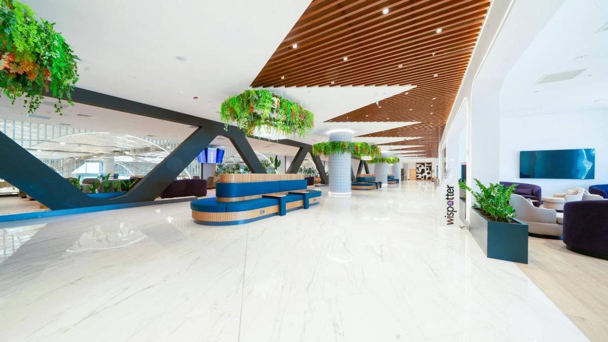a lobby with chairs and potted plants in a building