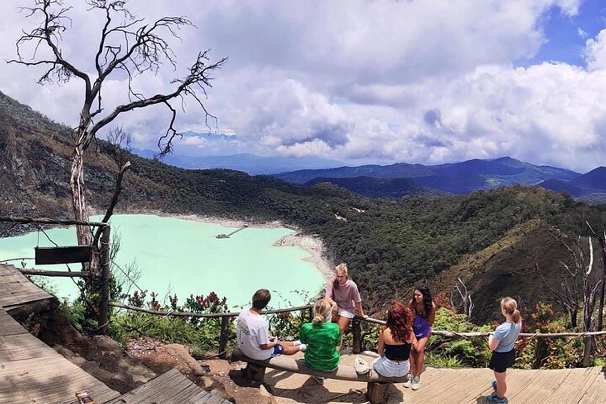 a group of people sitting on a bench overlooking a lake
